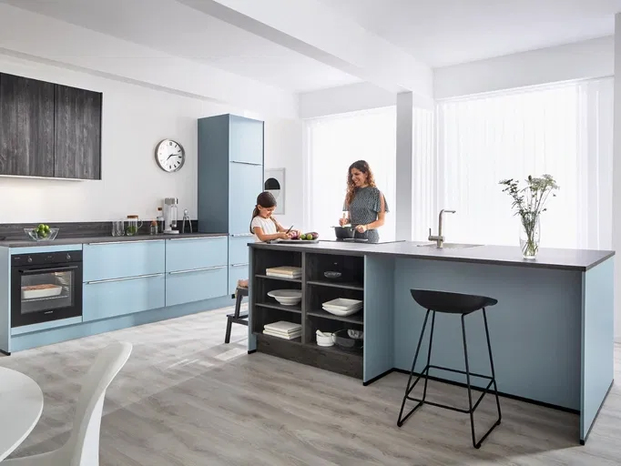 SlimLine Arbeitsplatte in einer stilvollen grifflosen Küche in Pastellblau mit großer Koch- und Spülen-Insel mit Thekensitzplätzen